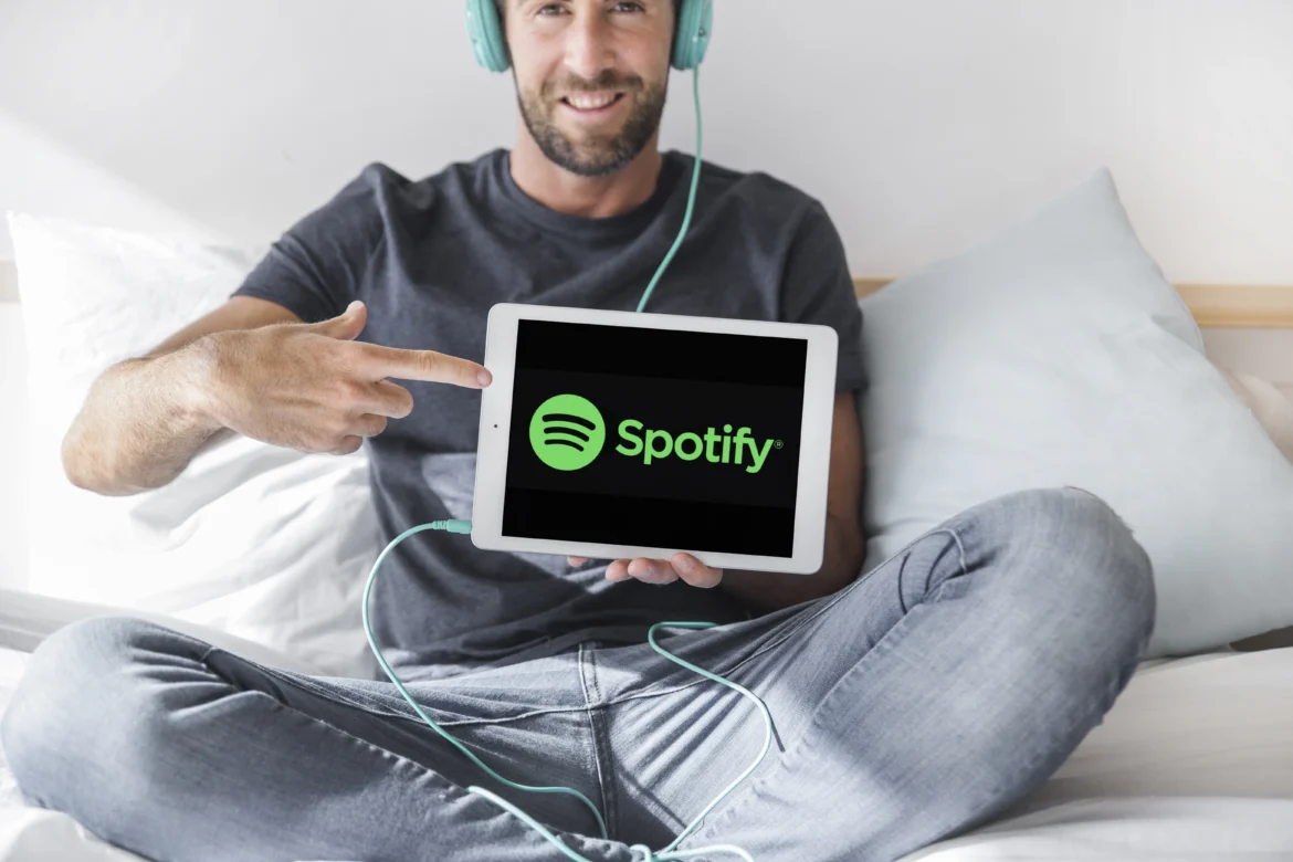 Decoding Spotify DNA: How Data Science Empowers and Revolutionizes Your Music Universe a man sitting on a bed holding a tablet, Spotify DNA